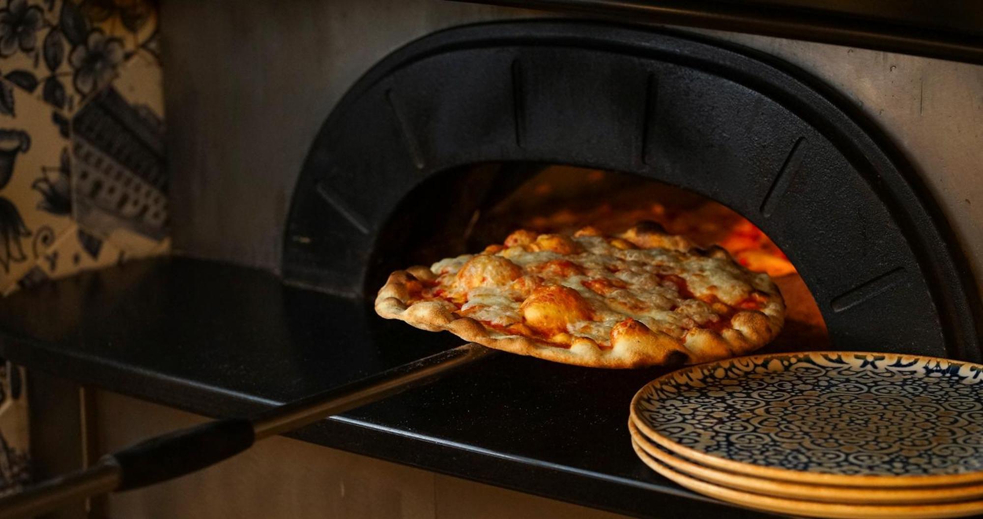 Eme Catedral Mercer Hotel Sevilla Exterior foto Pizza being removed from a wood-fired oven